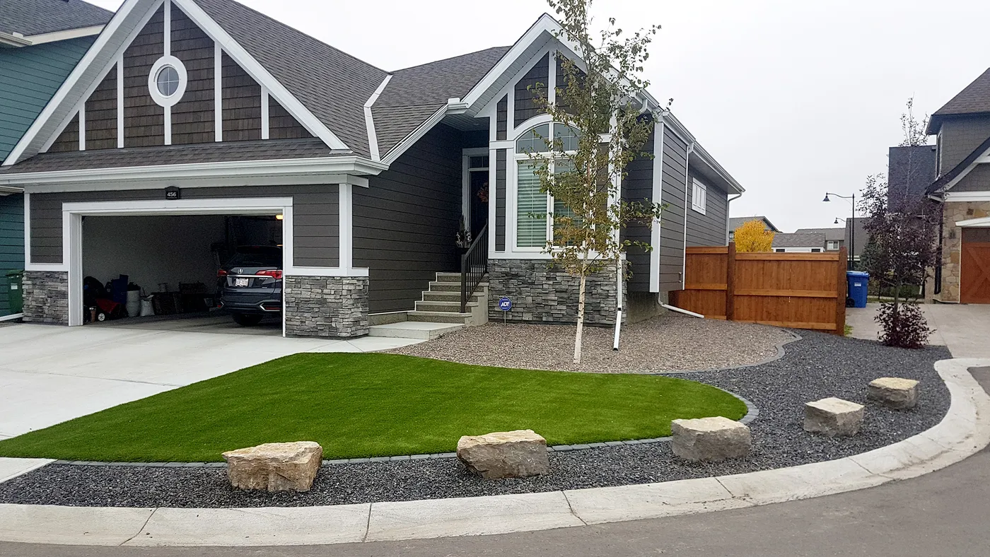 Completed Calgary backyard landscape with lawn, stonework and layered planting