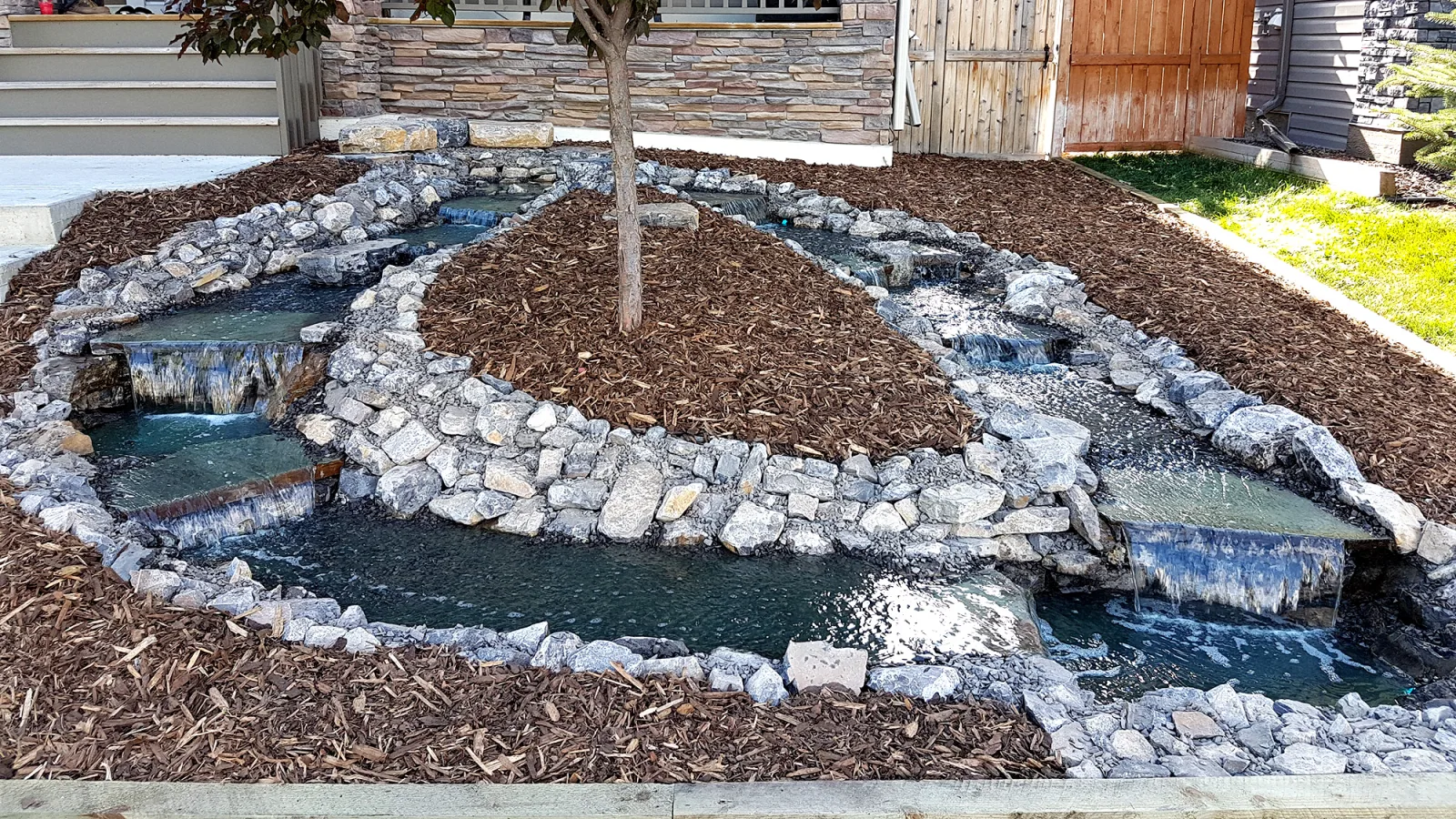 Multi-level natural stone water feature in a residential landscape